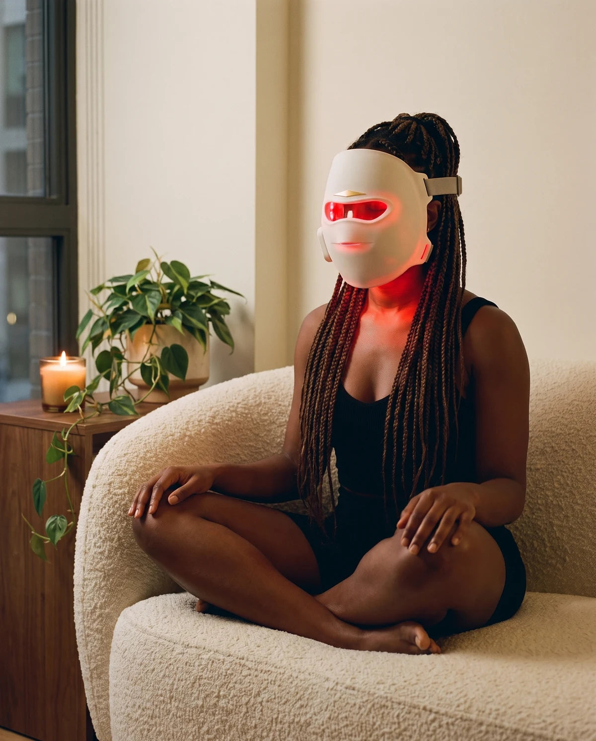 A woman sitting on a sofa wearing the mask, glowing red