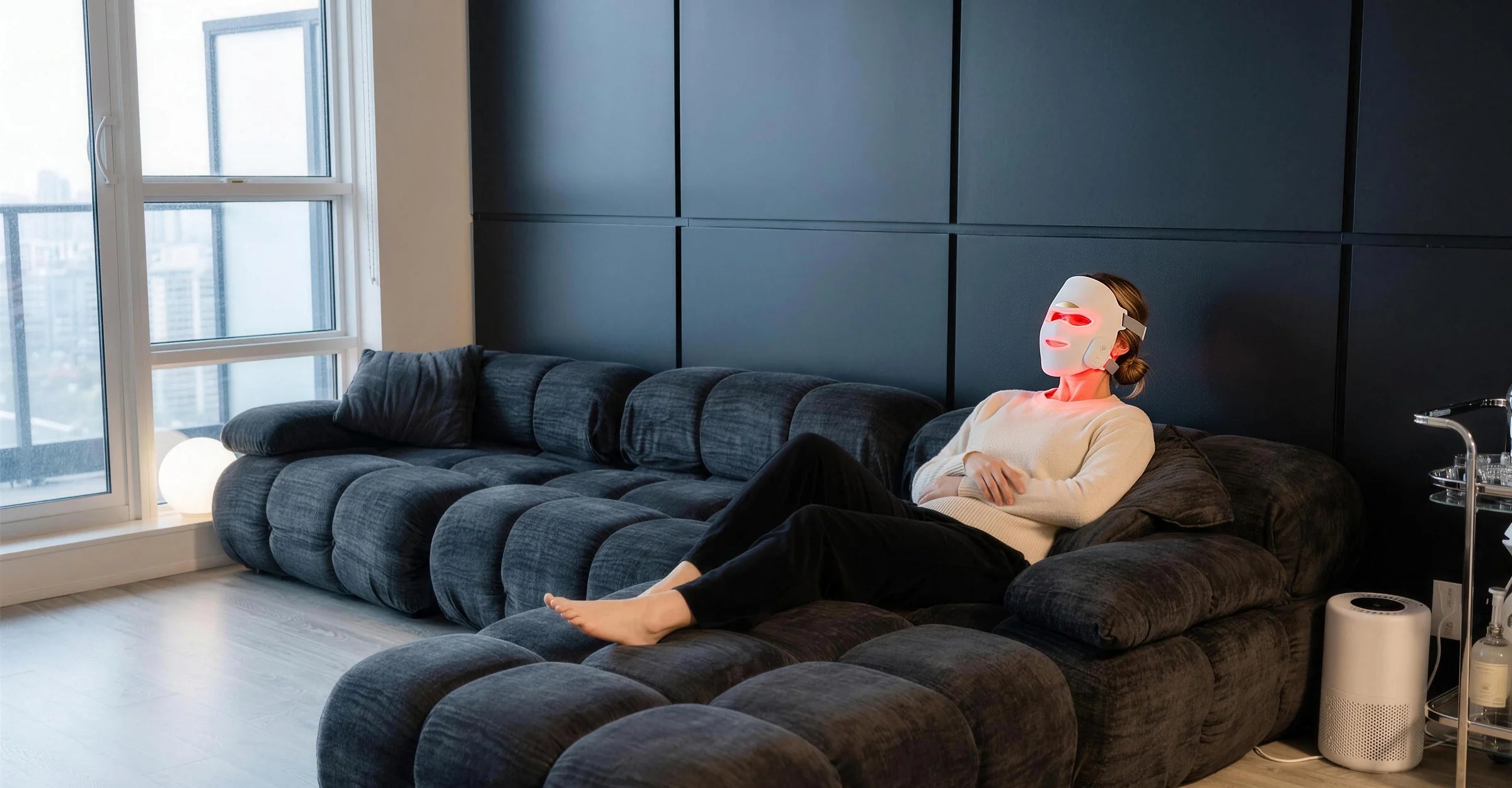 A woman resting on a sofa wearing the Sorisse Mask, glowing red